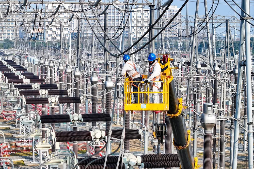 Workers upgrade transmission lines. Eurelectric says investment into grid infrastructure is crucial.
